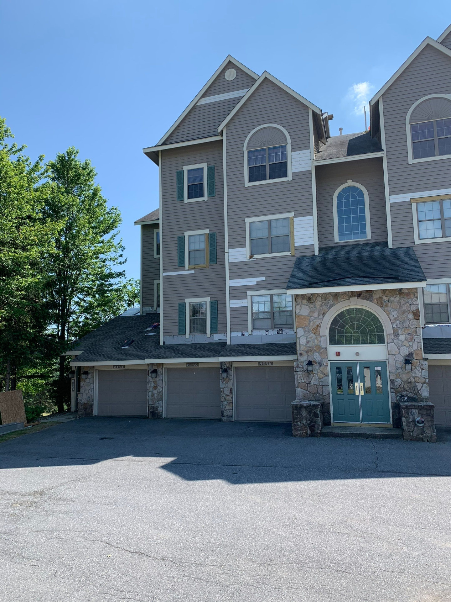 Multi-unit condo building with siding replacement underway around windows and gables