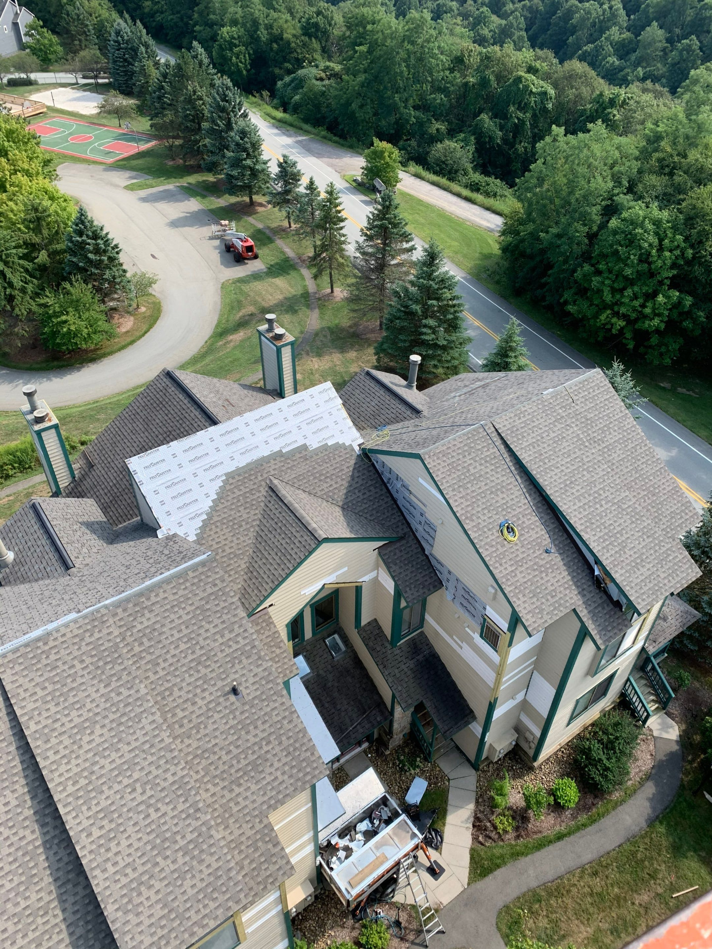Aerial view of a large home mid re-roof with FeltBuster underlayment and siding removed