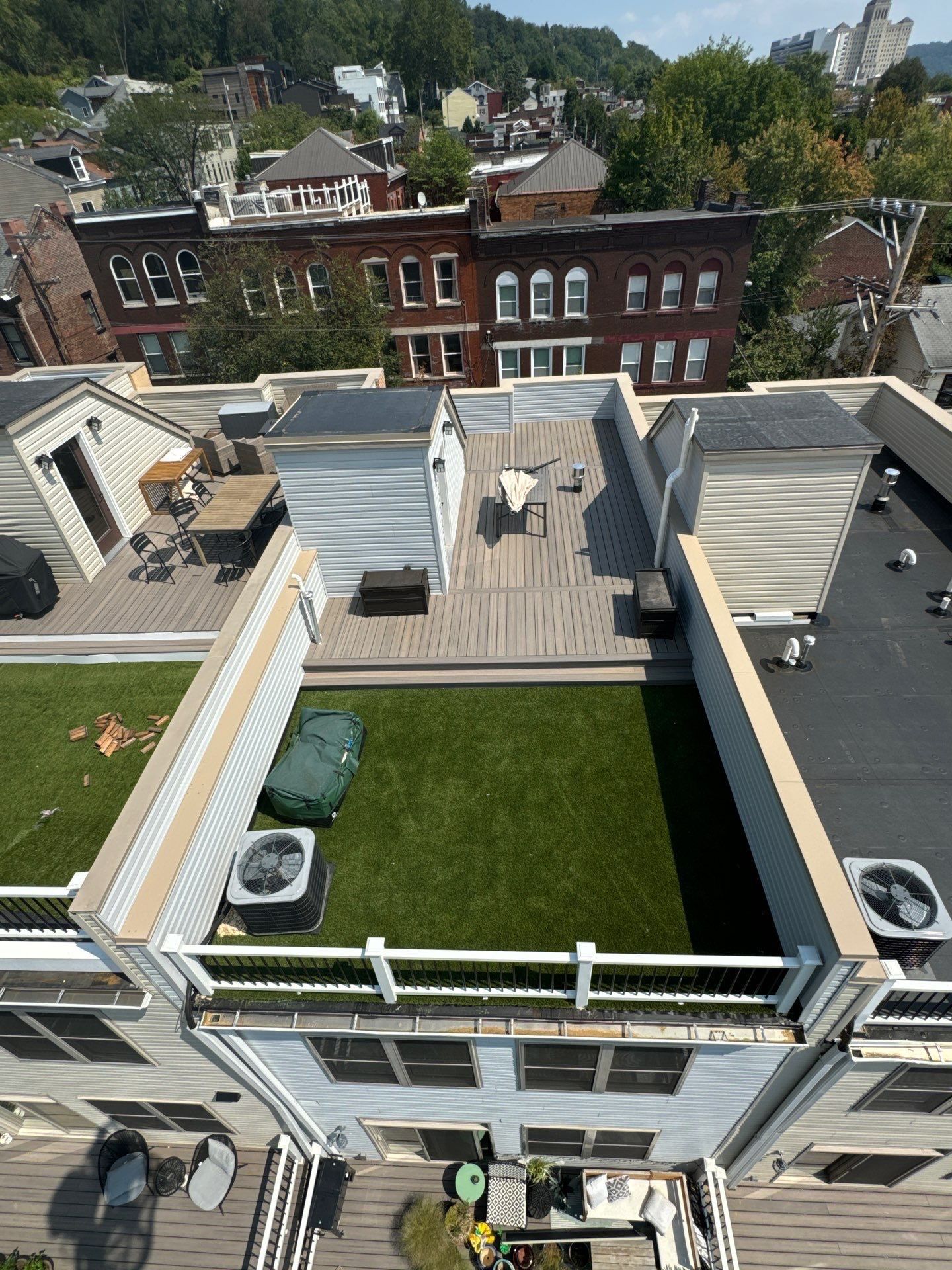Rooftop deck and flat membrane roof on a city rowhouse with turf and composite decking