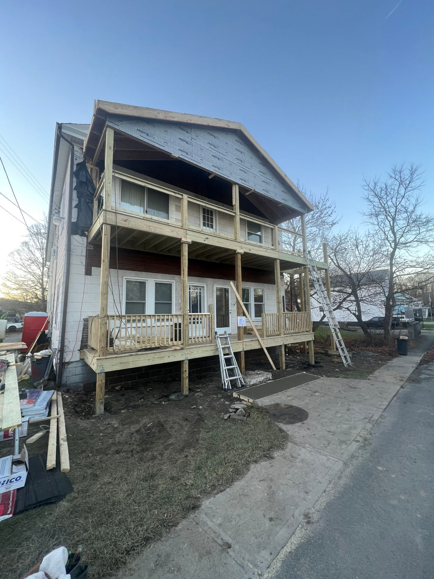 Two-story front porch framed in pressure-treated lumber with FeltBuster underlayment on the gable
