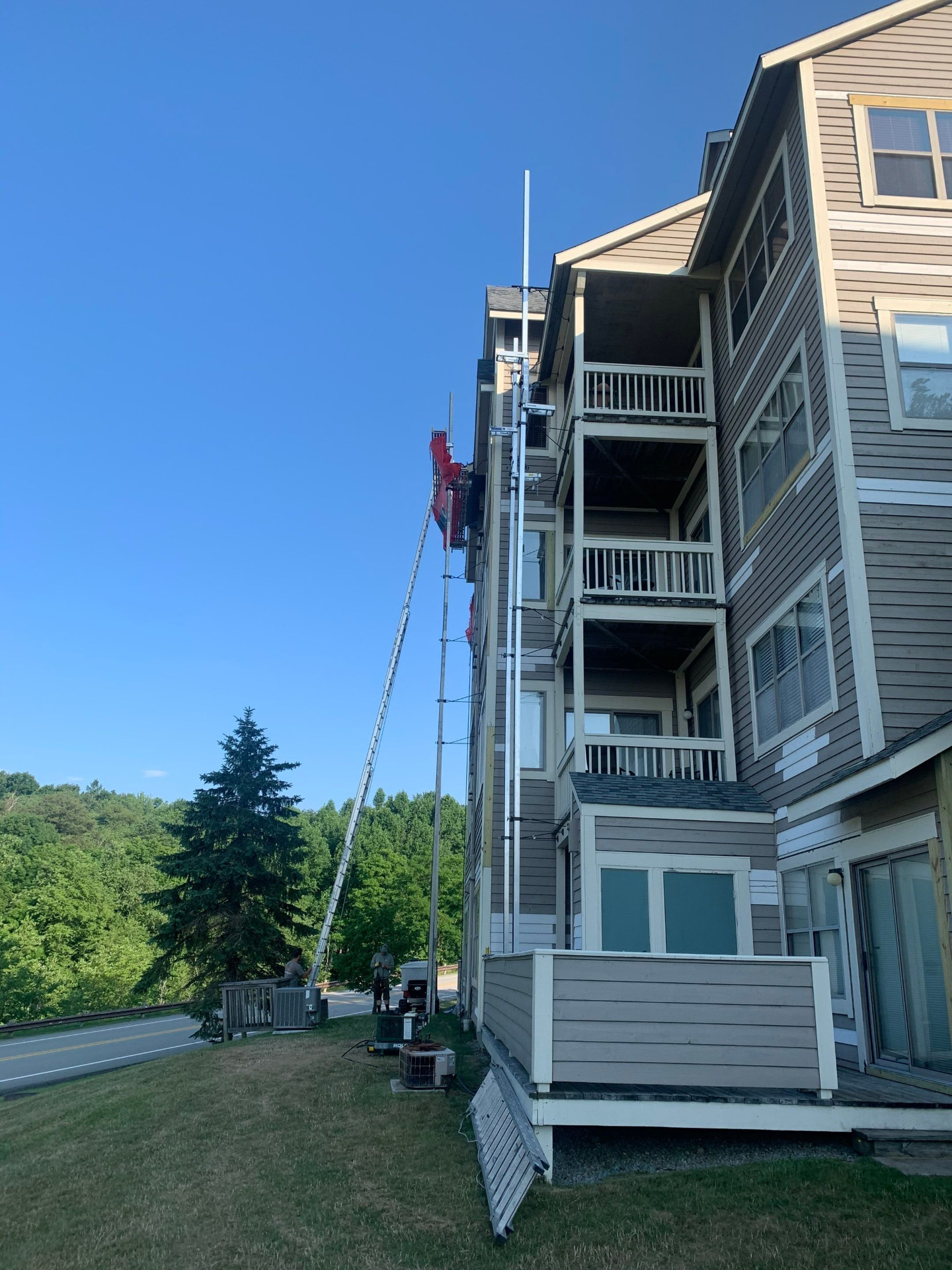 Multi-family building with siding replacement underway from a ladder hoist