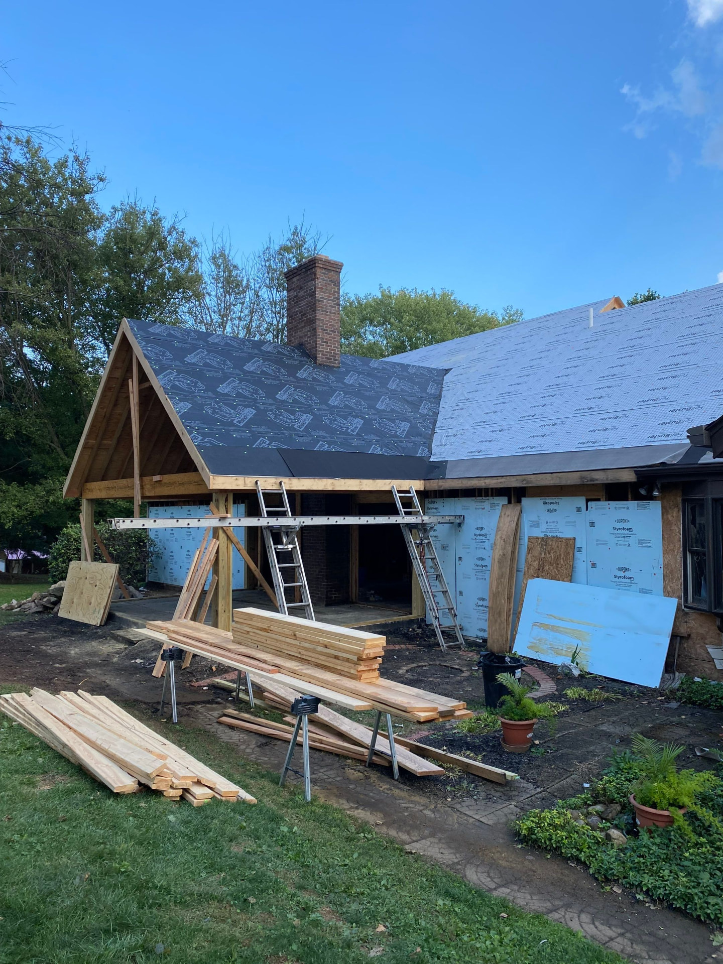 New timber porch roof framing with underlayment installed over an attached garage