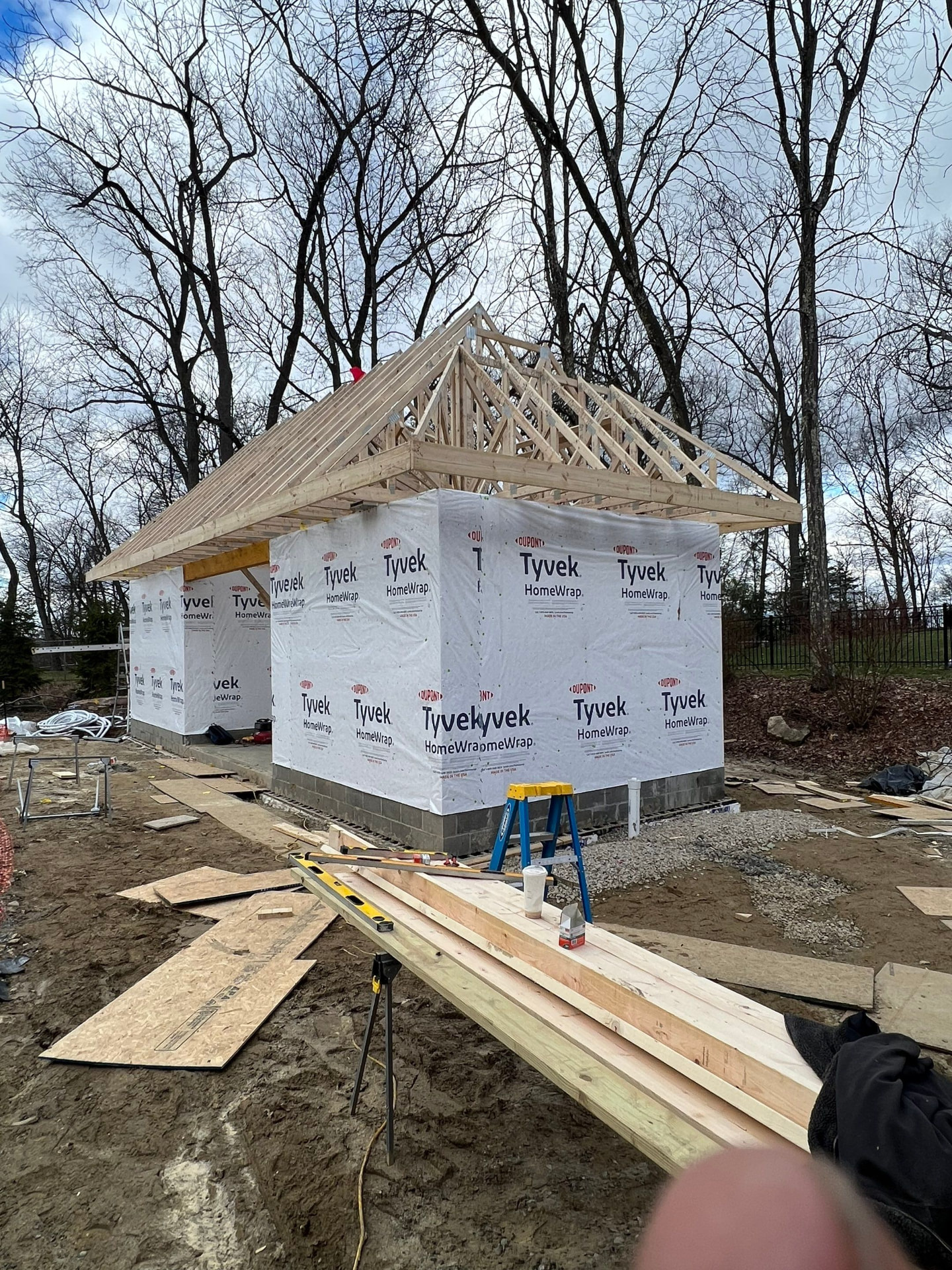 New detached garage with roof trusses set and Tyvek house wrap installed