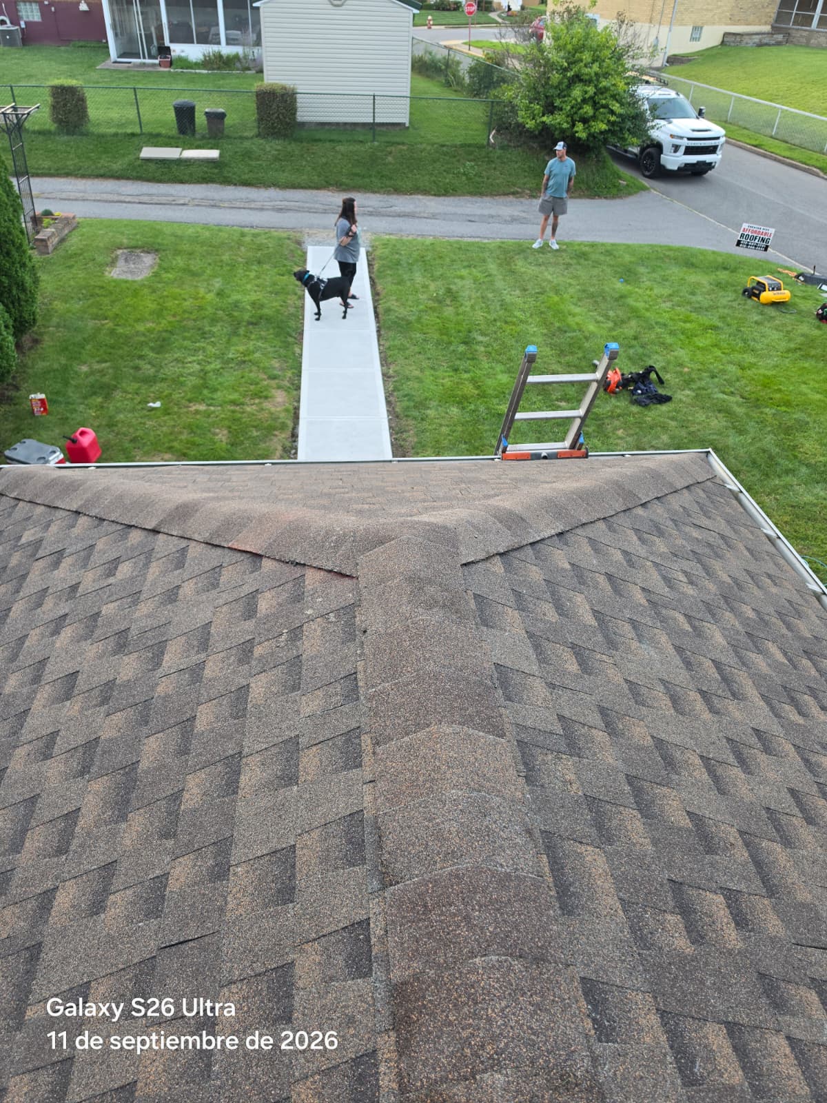 Hipped roof with brown architectural shingles and an Affordable Roofing yard sign on the lawn