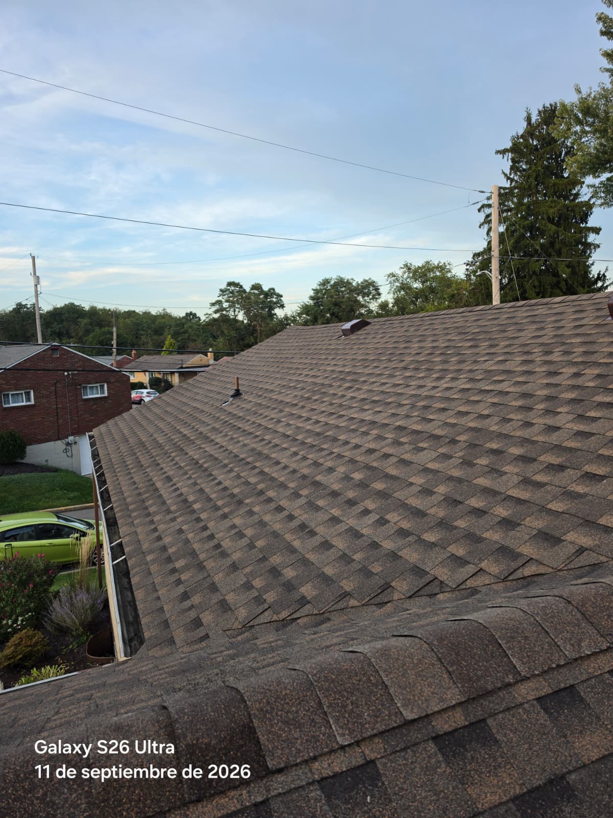 Close-up of architectural asphalt shingles with a brown and black pattern on a residential roof