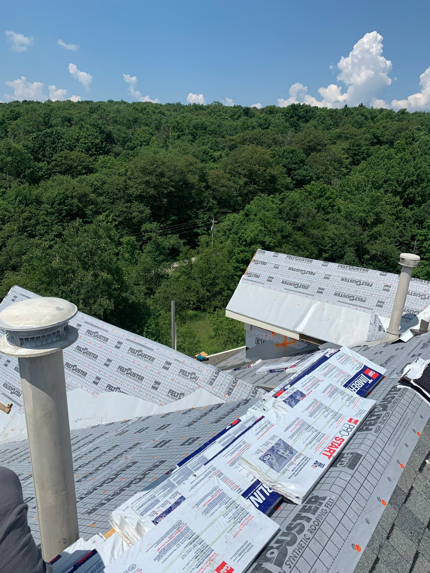 Roof dried in with FeltBuster underlayment and GAF Pro-Start starter strip staged at the dormers