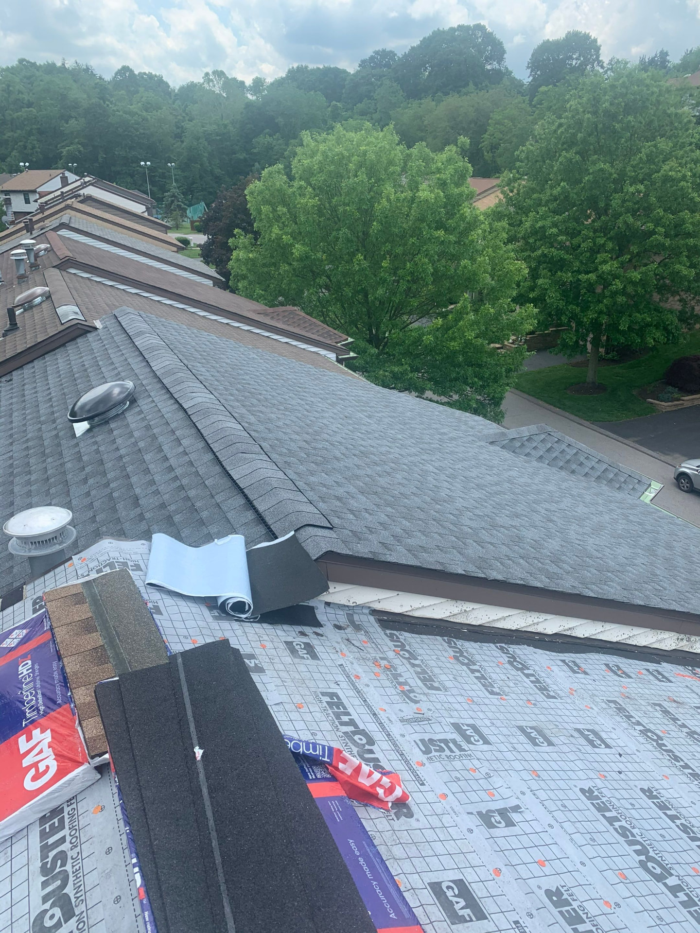 GAF FeltBuster underlayment and ridge cap shingles being installed on a townhome roof