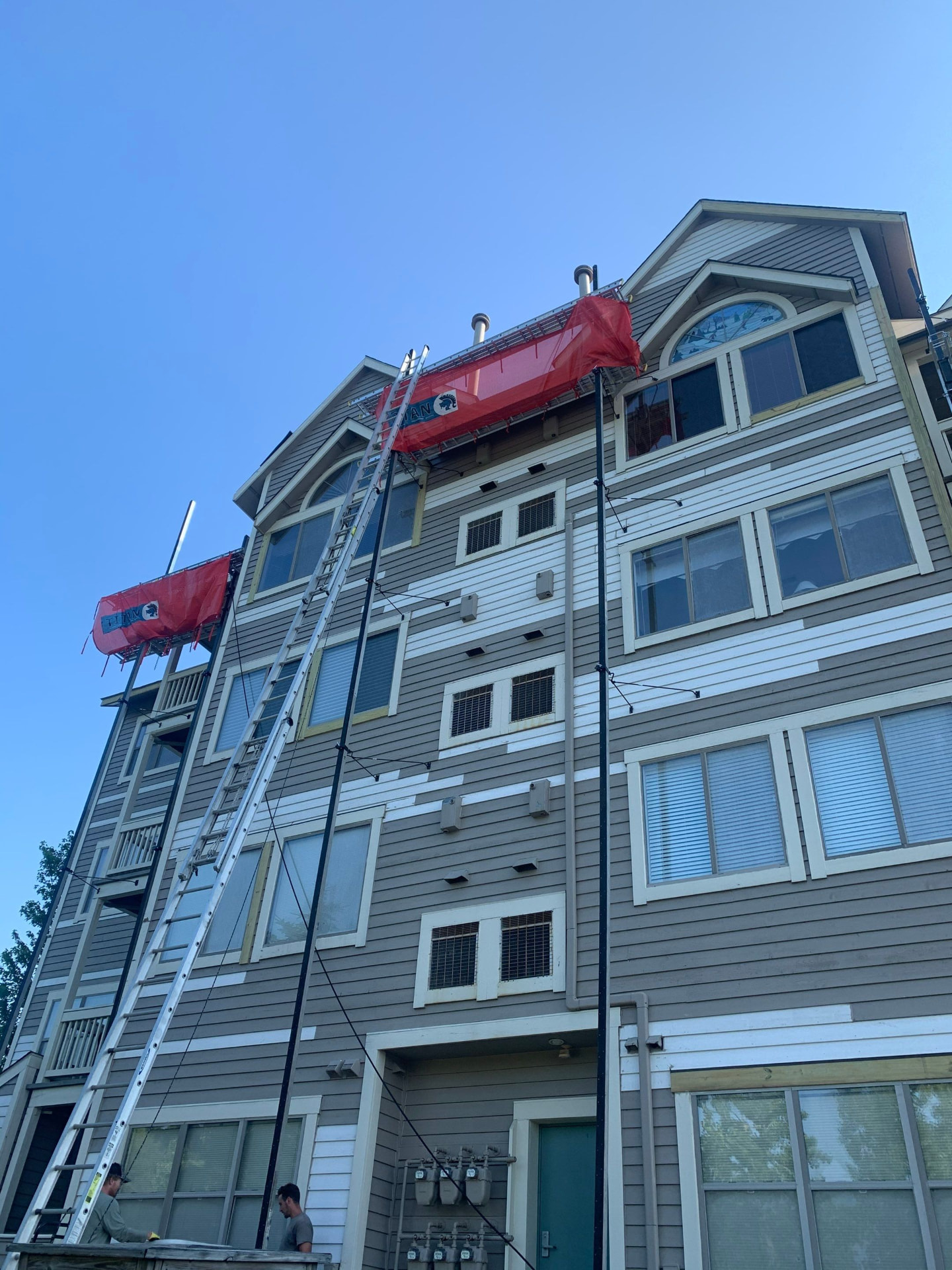 Four-story apartment building siding replacement using swing-stage platforms