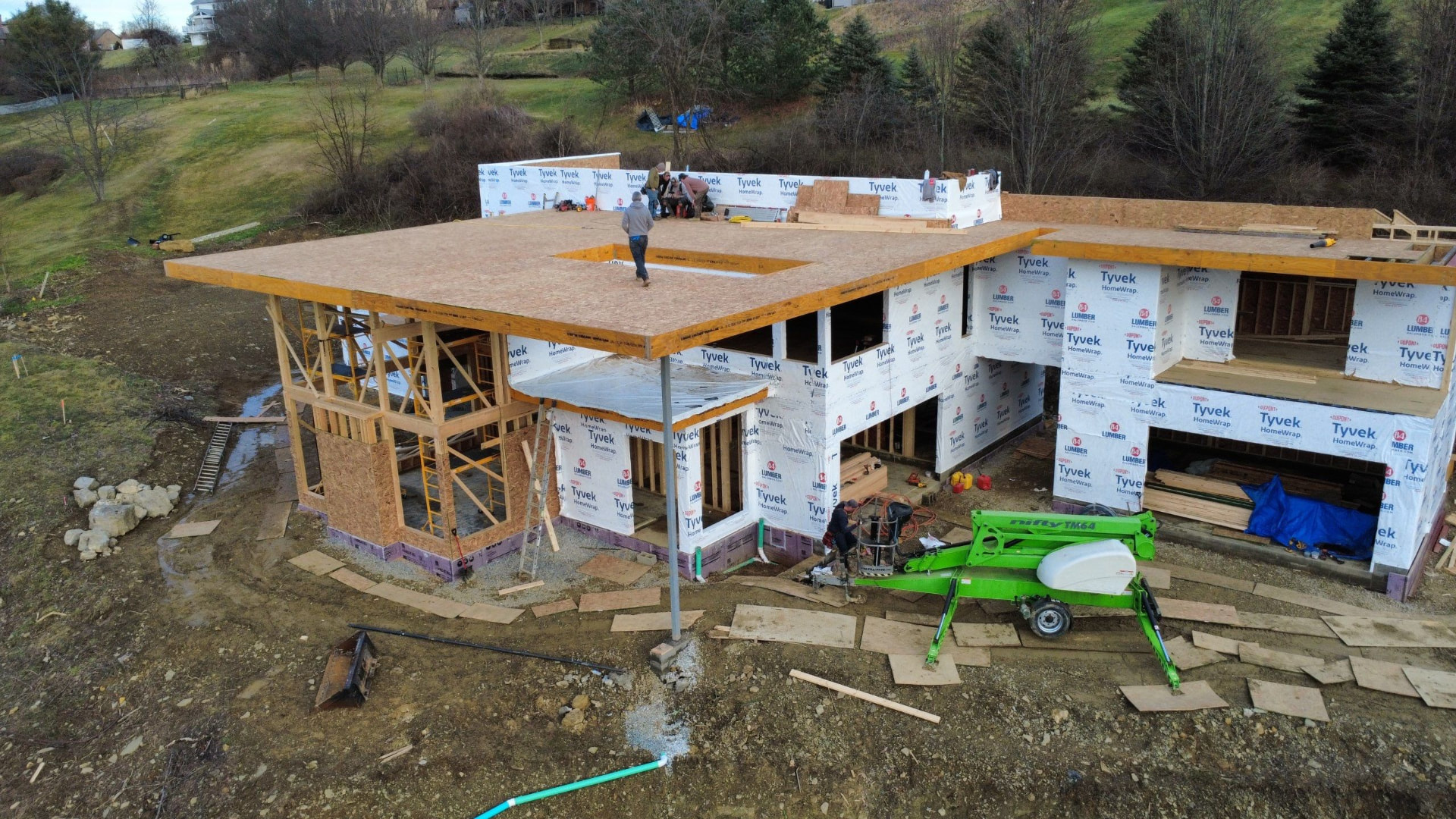 Drone view of a new build with Tyvek HomeWrap, OSB roof deck and a lift on site